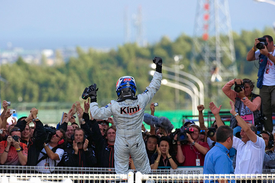 Kimi Raikkonen shaking his fist at parc ferme being cheered by his boss Ron Dennis.