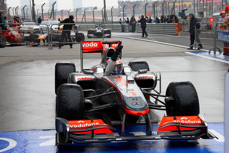 Race winner Jenson Button arrives in parc ferme on nearly treadless tyres
