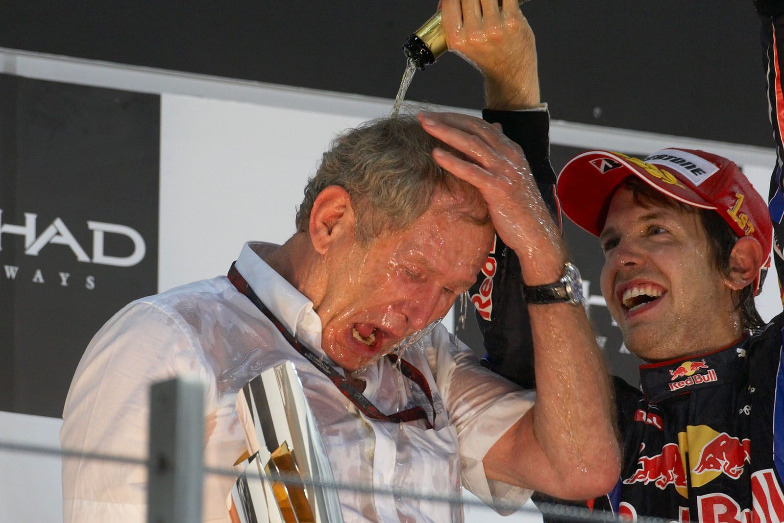 Red Bull's Helmut Marko celebrates on podium with race winner Sebastian Vettel