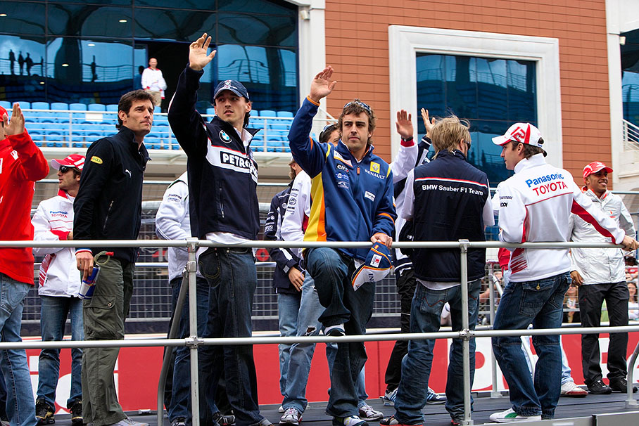 Kubica and Alonso wave at the cheering fans at the start of the drivers parade