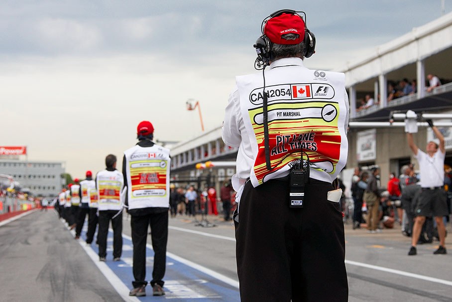 Pit lane marshals stand in line for an inspection