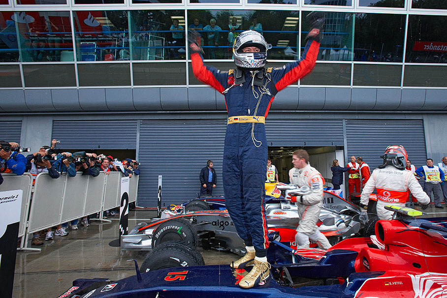 Celebrated polesitter Sebastian Vettel climbs on the Toro Rosso car in parc ferme