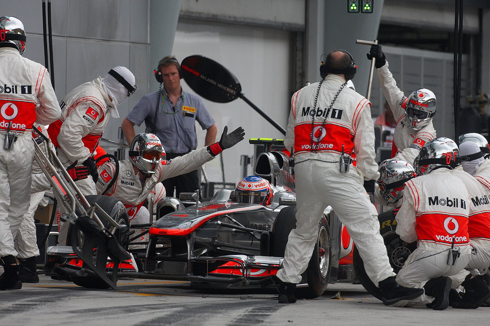 Jenson Button is serviced at McLaren pits