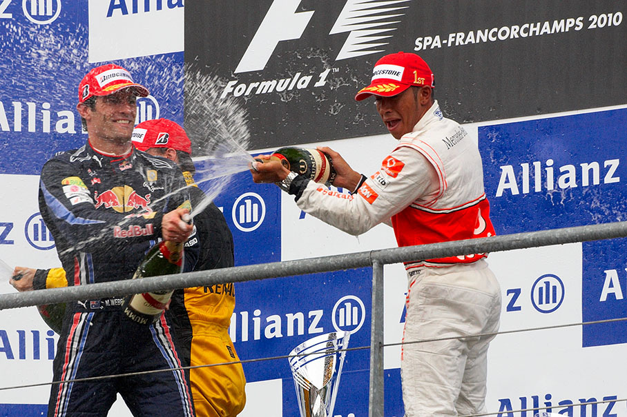 Winner Hamilton and second placed Webber spray champagne on the podium after the Belgian GP