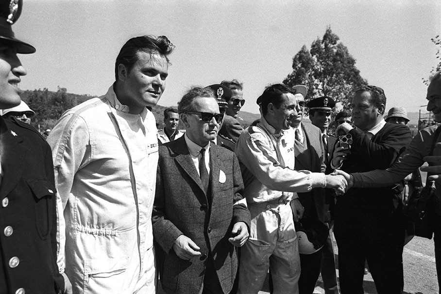 Dr. Ferry Porsche walks through pitlane with his winning drivers Udo Sch¸tz (left) and Gerhard Mitter (right) well guarded by the Sicilian 'carabinieri'