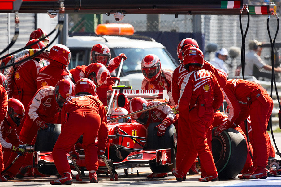 Kimi Raikkonen performs a pit stop ballet with Ferrari's pit crew