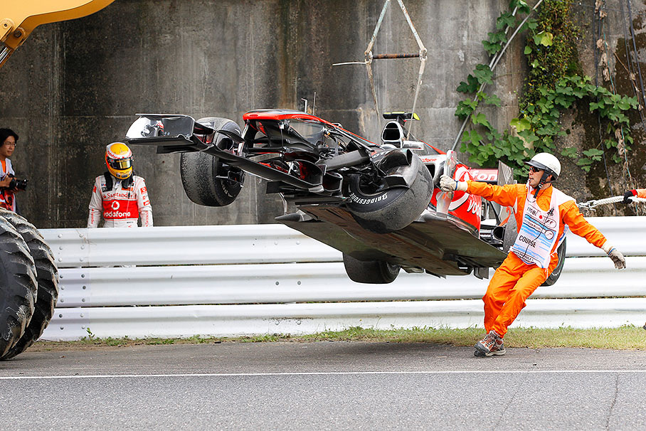 During Friday's practice session, Lewis Hamilton watches the marshals who drag the McLaren Mercedes car besides the track