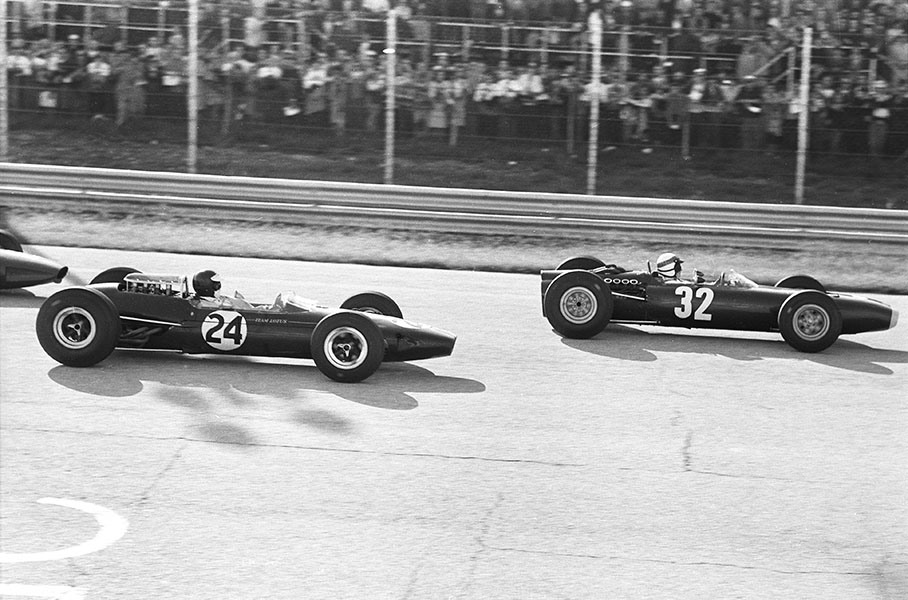 Race winner Jackie Stewart on a BRM P261 and Jim Clark in a Lotus-Climax 33 (car no. 24, started from pole position but retires with fuel pump problems after 63 of 76 laps) fight wheel to wheel for the lead during the Italian GP at Monza in 1965.