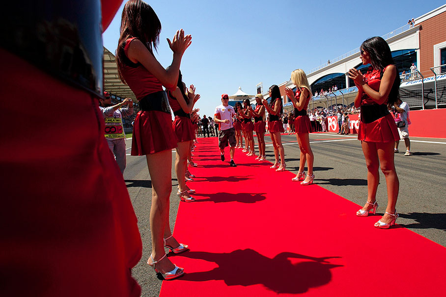 Kimi Raikkonen, again late, runs behind to drivers parade truck