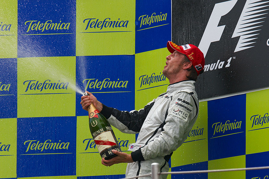 On the Spanish podium, Jenson Button sprays champagne and celebrates his fourth victory in five races