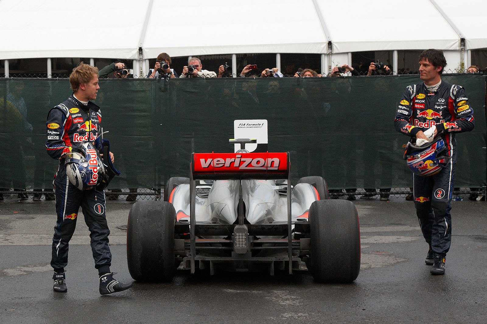 Red Bull team mates Sebastian Vettel and Mark Webber walk round Button's winning McLaren-Mercedes in parc ferme