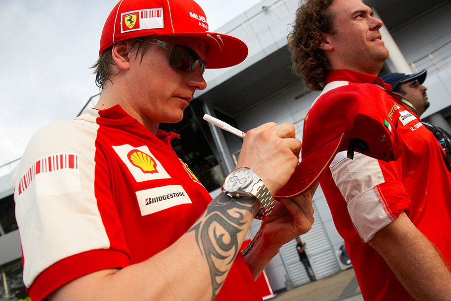 Kimi Raikkonen signs a Ferrari cap