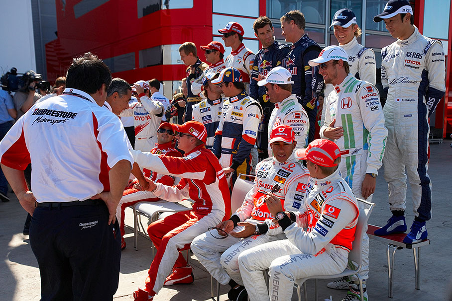 Kimi Raikkonen shakes hands with Hiroshi Yasukawa, director of Bridgestone Motorsport