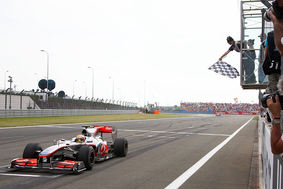 McLaren's Lewis Hamilton takes the chequered flag and wins the Turkish Grand Prix 2010, team mate Button is close behind