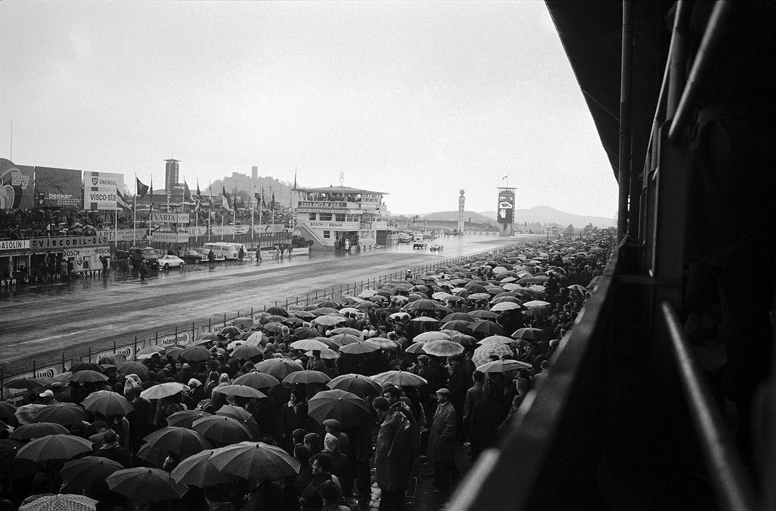 Two cars fight in the rain at the beginning of the main straight