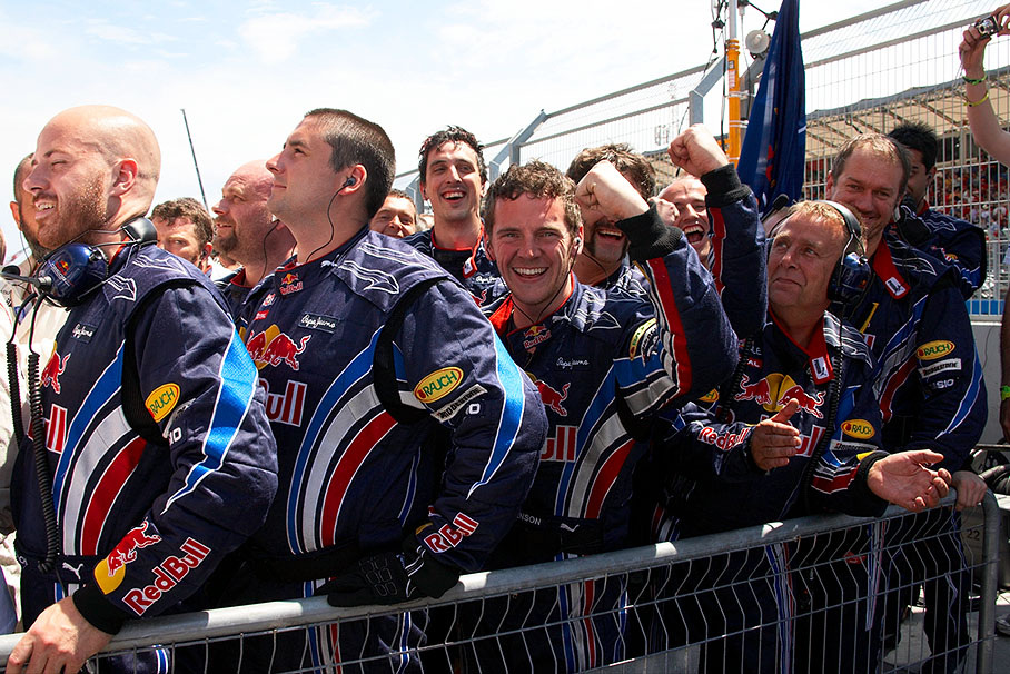 Happy Red Bull mechanics celebrate besides parc ferme