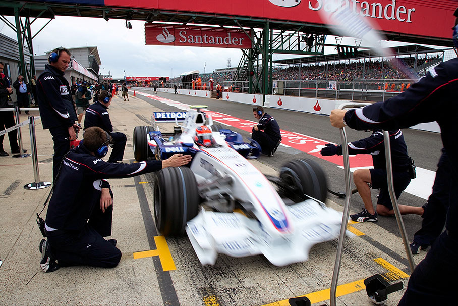 Robert Kubica practices a pit stop with his BMW Sauber mechanics