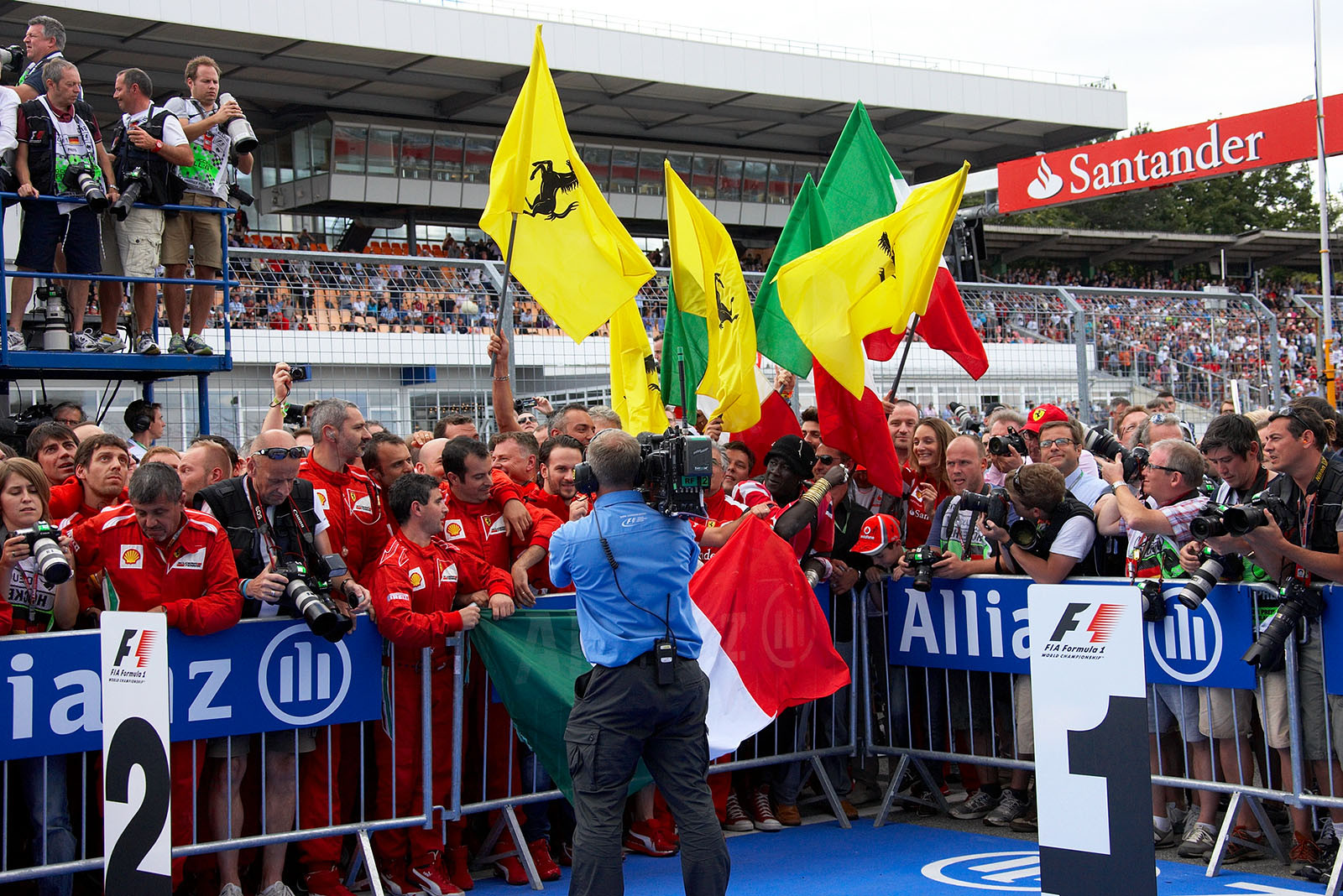 The Ferrai mechanics celebrate besides parc ferme Alonso's achievement