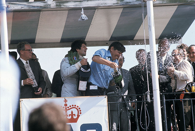 Race winner Jody Scheckter and team boss Ken Tyrrell celebrate with champagne on podium, British GP Brands Hatch 1974