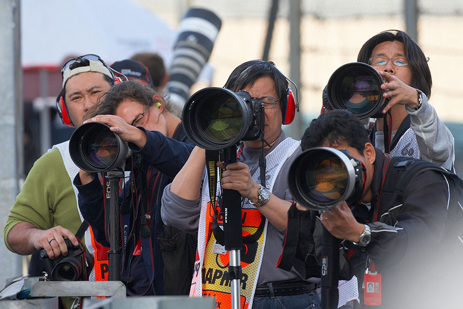 Photographers wait with their long lenses for the pole position sitter