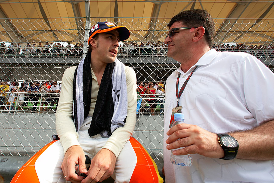 Fernando Alonso chats besides the grid with his physio Fabricio Borra
