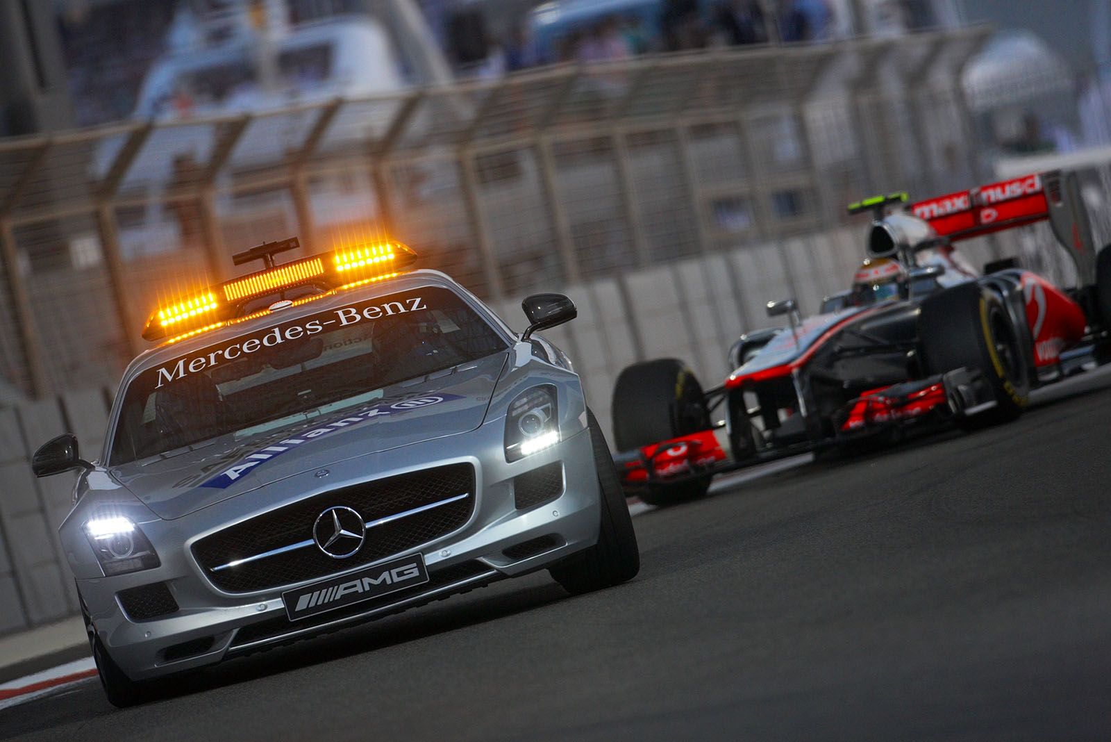Bernd Maylaender in the safety car leads the field with McLaren's Hamilton still in front whilst the track is cleaned after an accident
