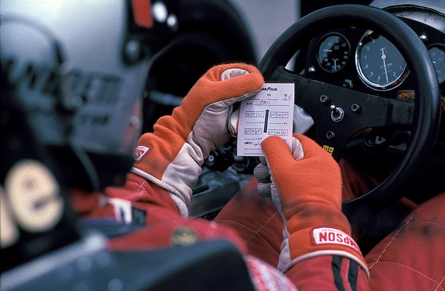 Mario Andretti reads his Goodyear tyre data sheet in the cockpit