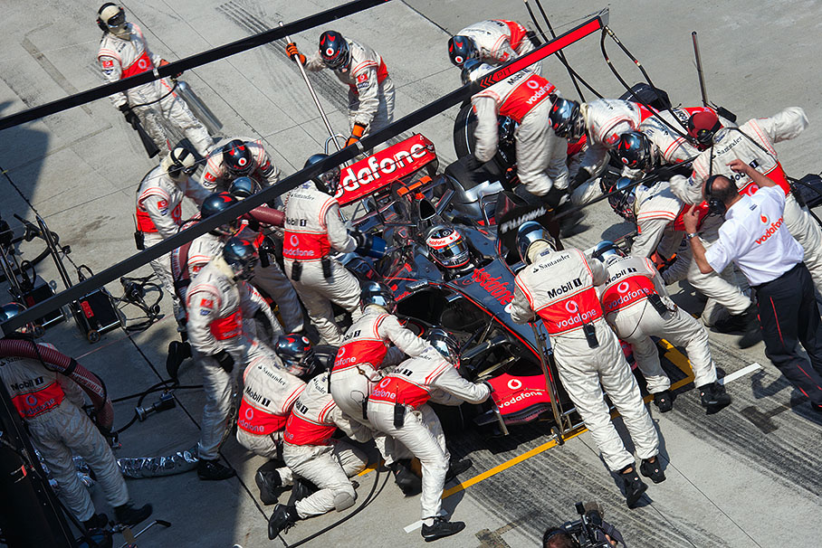 Fernando Alonso's first pit stop in lap 18, note Ron Dennis giving signs about bad radio connection