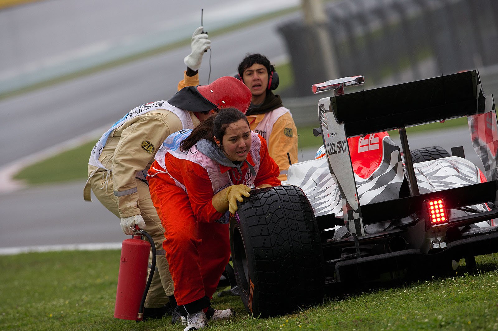 The female marshals often had to do the hardest work - like pushing HRT's retired Karthikeyan away from the track