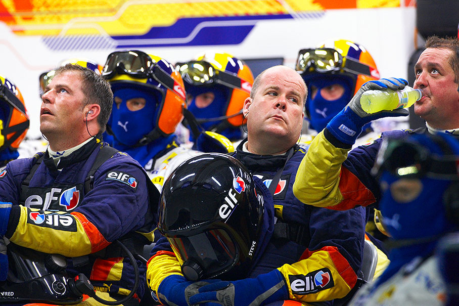 Renault mechanics watch the race on a screen in pits