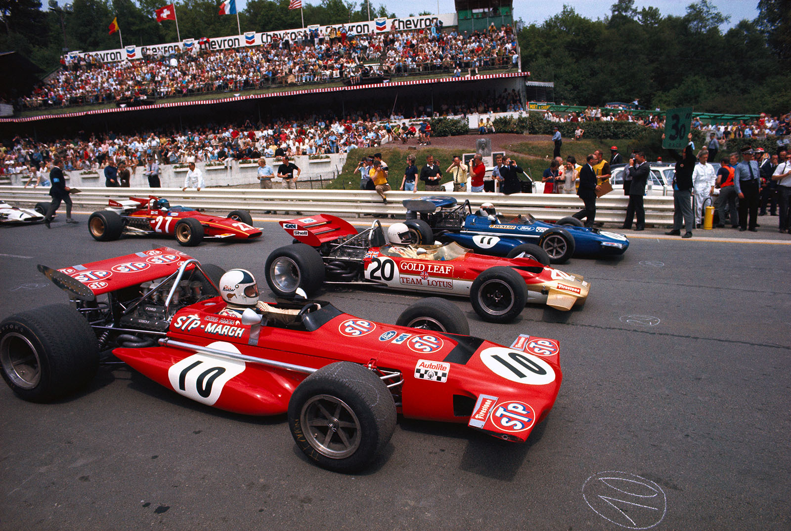 30 seconds before the start of the Belgian Grand Prix, Spa-Francorchamps, 1970. Pole position for Jackie Stewart, in the blue March no. 11. Alongside him sharing the front row are Jochen Rindt, Lotus, and Chris Amon, March no. 10.