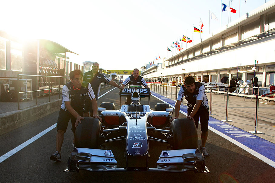 Williams mechanics roll the car through pitlane