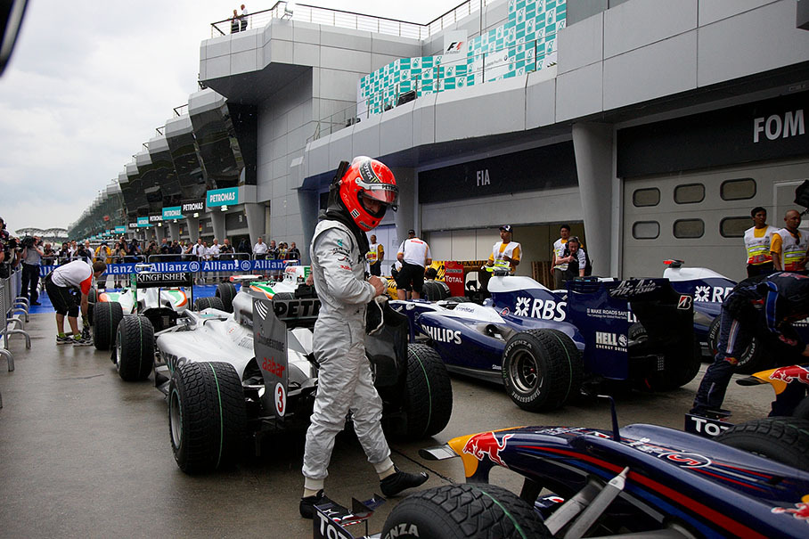 Michael Schumacher takes a close look at his opponents' cars in parc ferme after qualifying