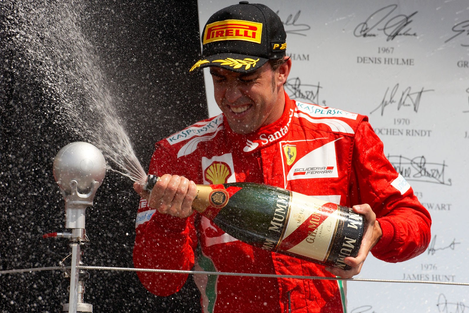 Second placed Fernando Alonso of Ferrari sprays champagne on the podium