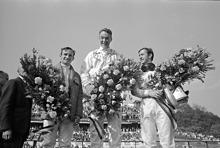 A surprising winner Dan Gurney on Eagle-Weslake T1G grins from the podium with a second placed Jackie Stewart on BRM P83 and third placed Chris Amon on a Ferrari P312