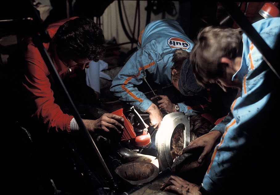 J. W. Automotive Engineering mechanics try to repair a Porsche 917L at night