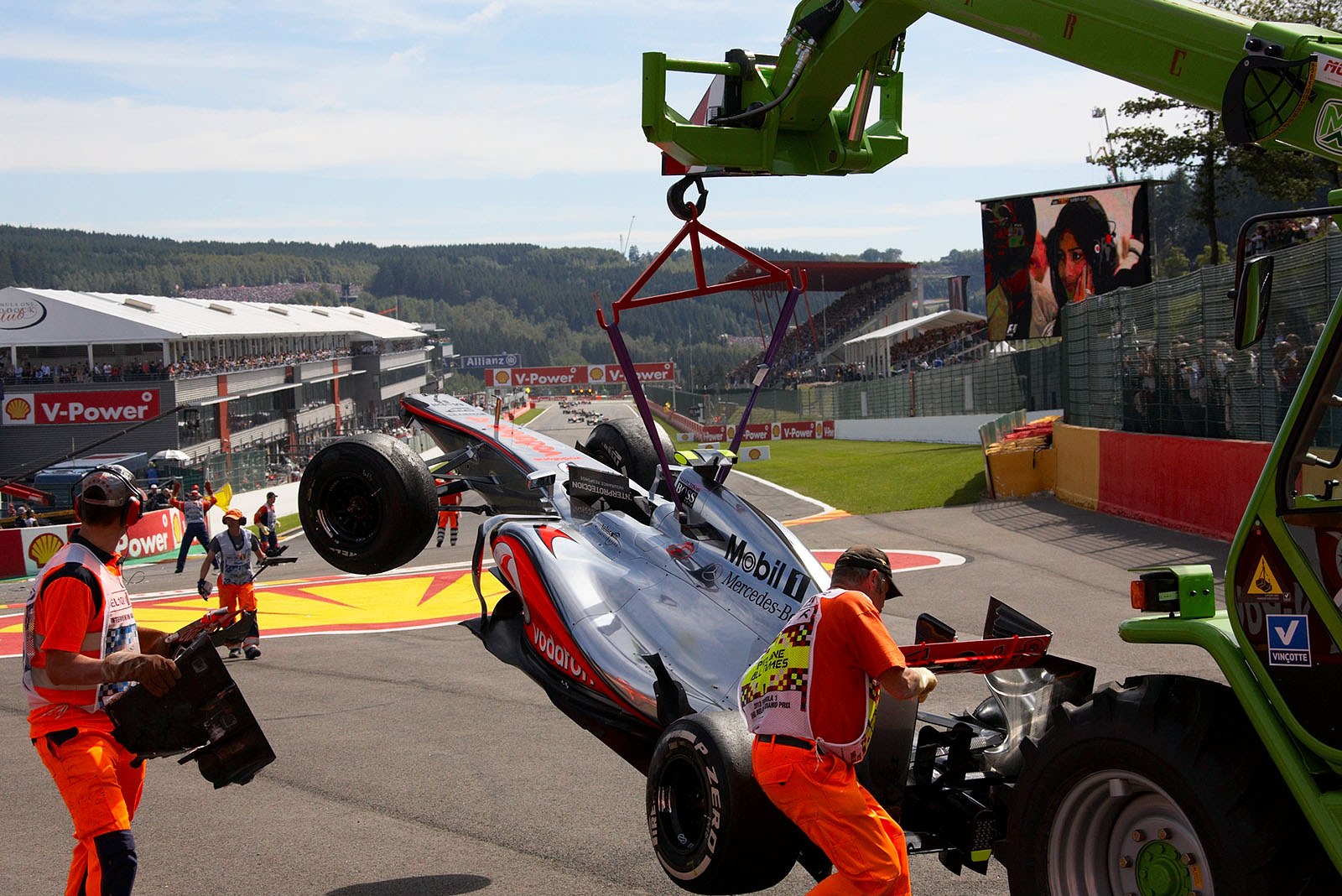 Lewis Hamilton's McLaren Mercedes is towed away after the start accident in turn one