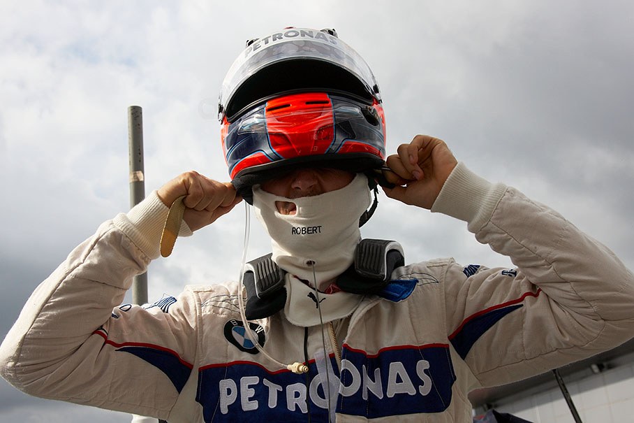 On grid shortly before the race, Robert Kubica puts his helmet on