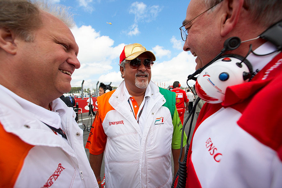 Force India team principal Vijay Mallya meets on the grid with Toyota's team boss John Howett
