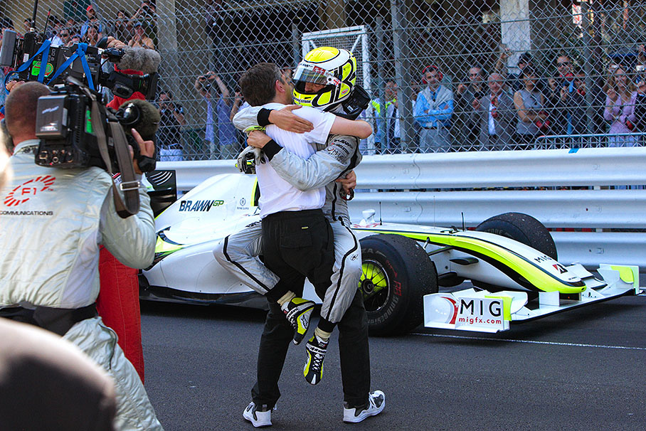 Race winner Jenson Button jumps on Brawn Grand Prix CEO Nick Fry in parc ferme