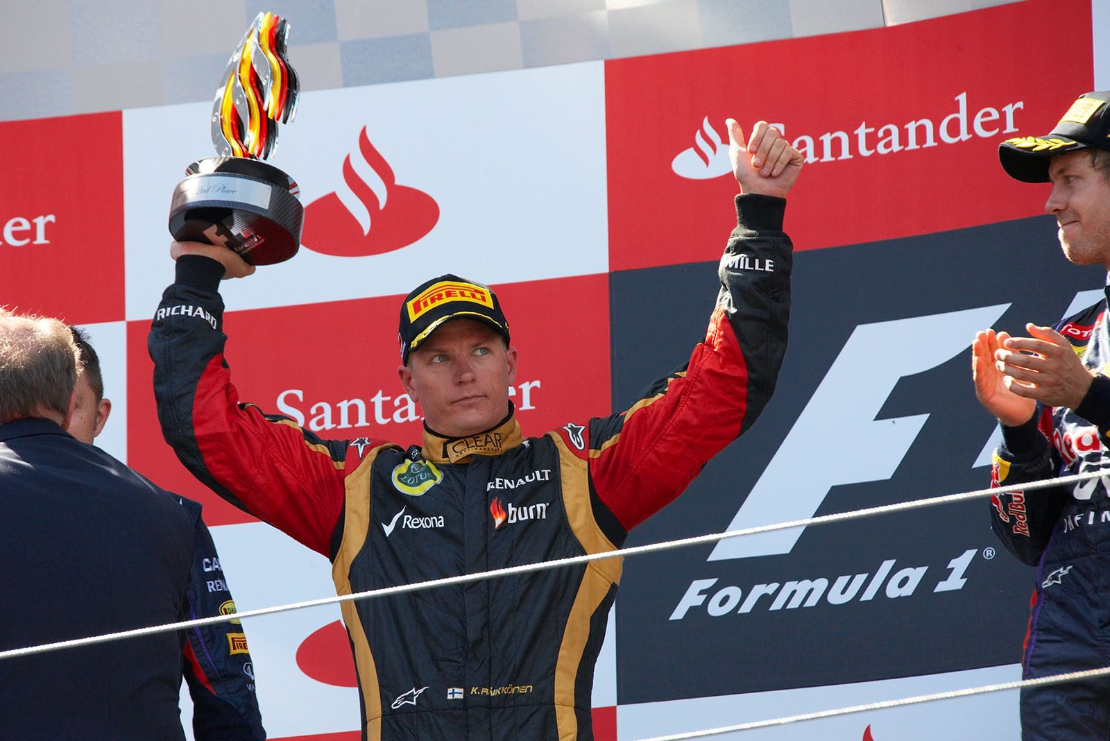 Second placed Kimi Raikkonen of Lotus presents his trophy and shows his famous backholding smile