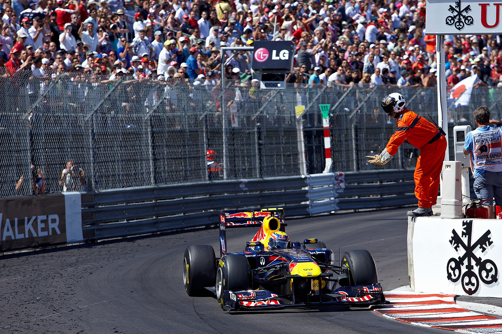 A marshal signals Mark Webber of Red Bull Racing to slow down