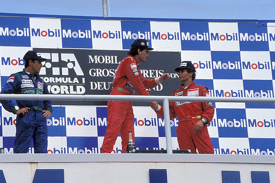 Race winner Ayrton Senna congratulates third placed Gerhard Berger on podium of the German GP Hockenheim 1990