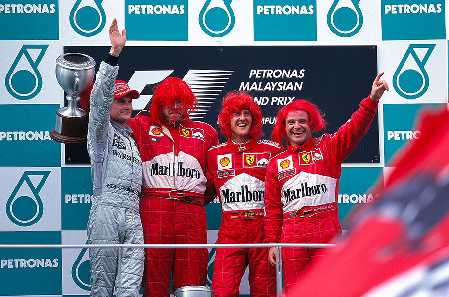 After the 2000 Malaysian Grand Prix Michael Schumacher, Rubens Barrichello and Ross Brawn wear red wigs to celebrate the Italian team's victory in the Constructors' Championship