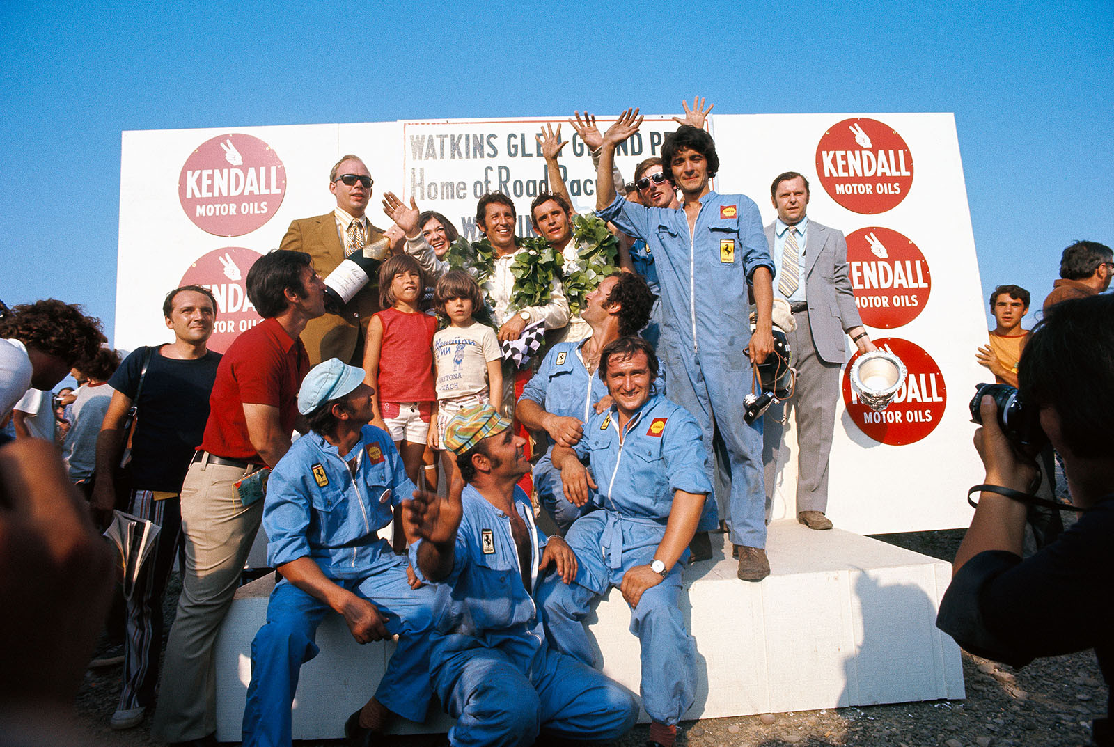 Mario Andretti (USA) on the podium with his kids, Jacky Ickx (B) and the winning Ferrari team members