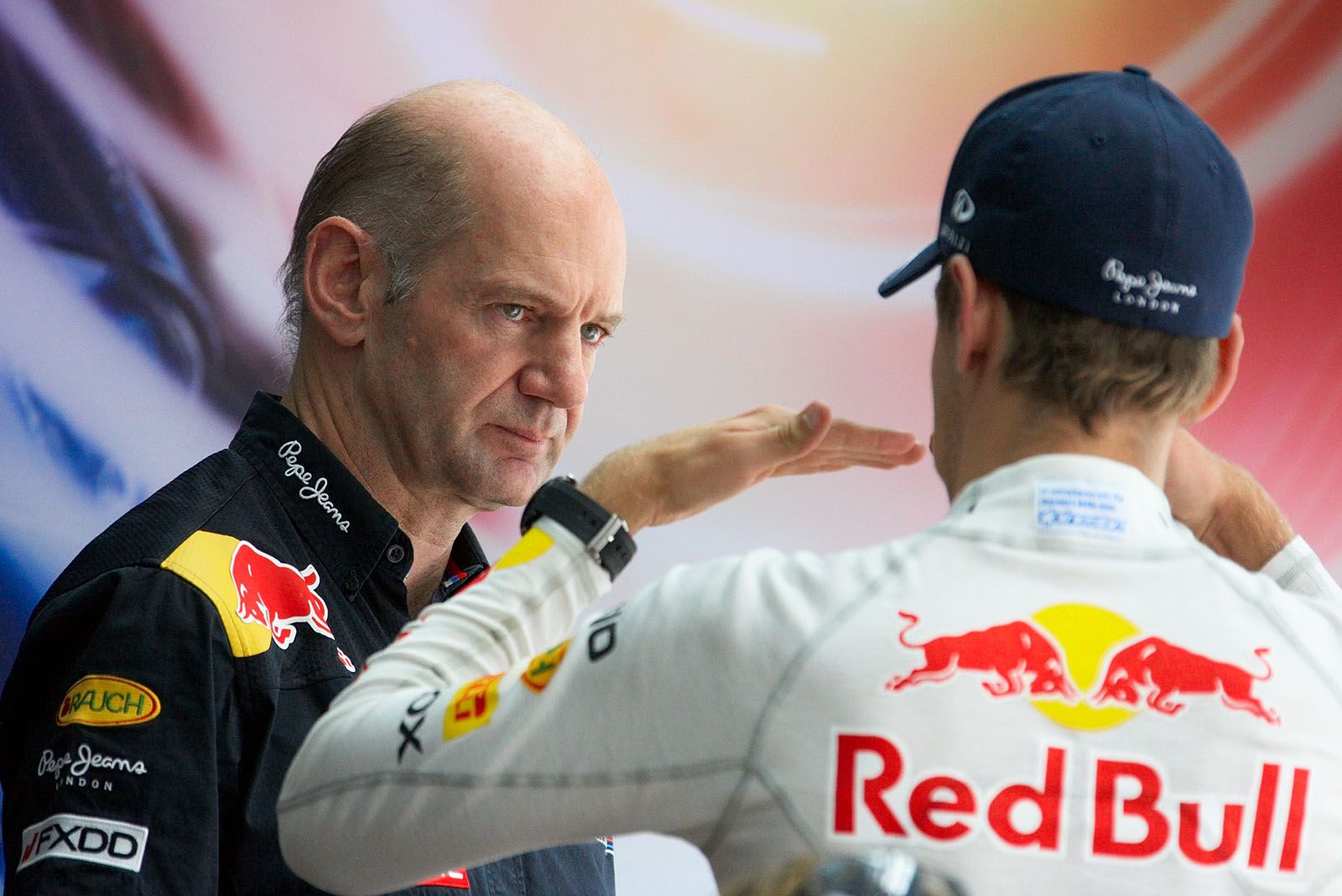 Red Bull Racing's technical director Adrian Newey listens to a gesticulating Sebastian Vettel