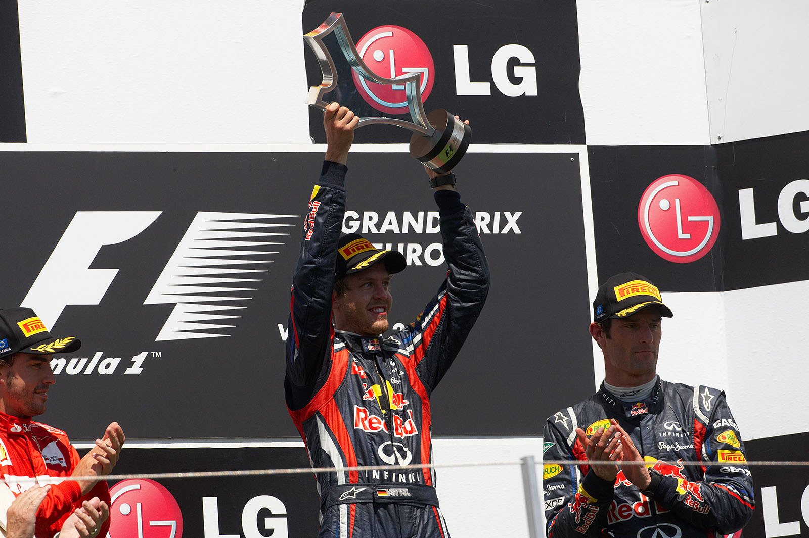 Race winner Sebastian Vettel raises his trophy on the podium