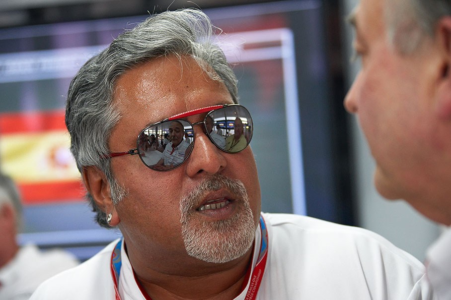Force India team boss Vijay Mallya speaks with John Howett of Toyota