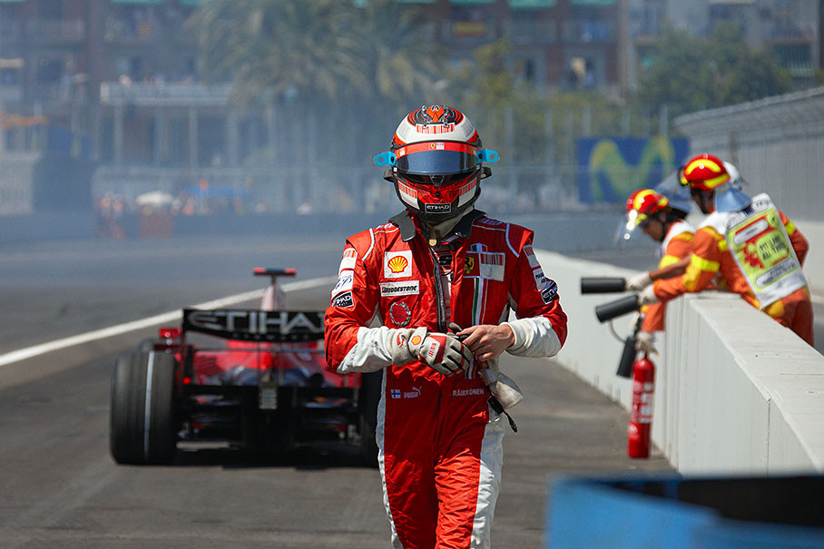 A frustrated Raikkonen walks away from a retired Ferrari car