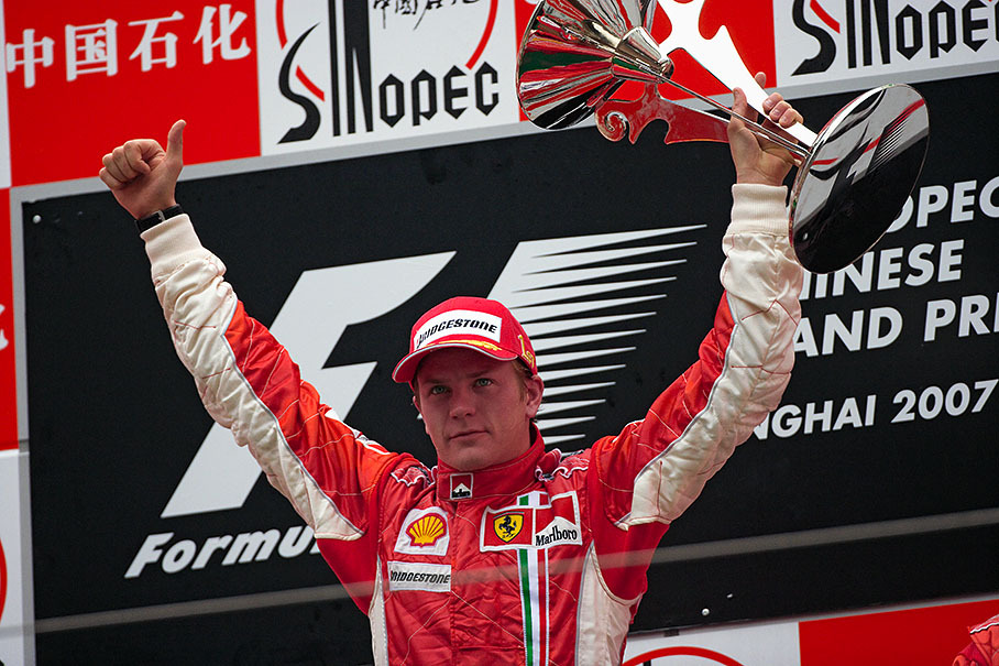 Kimi Raikkonen proudly celebrates his victory on podium